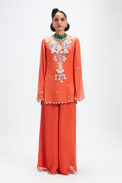 Woman wearing orange chiffon sharara set with dupatta