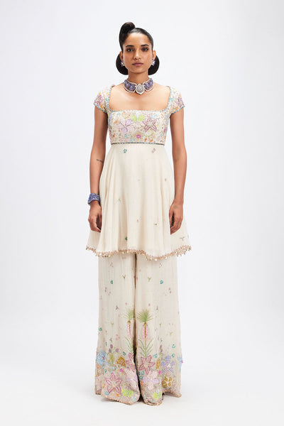 Woman wearing ivory embellished kurta sharara set