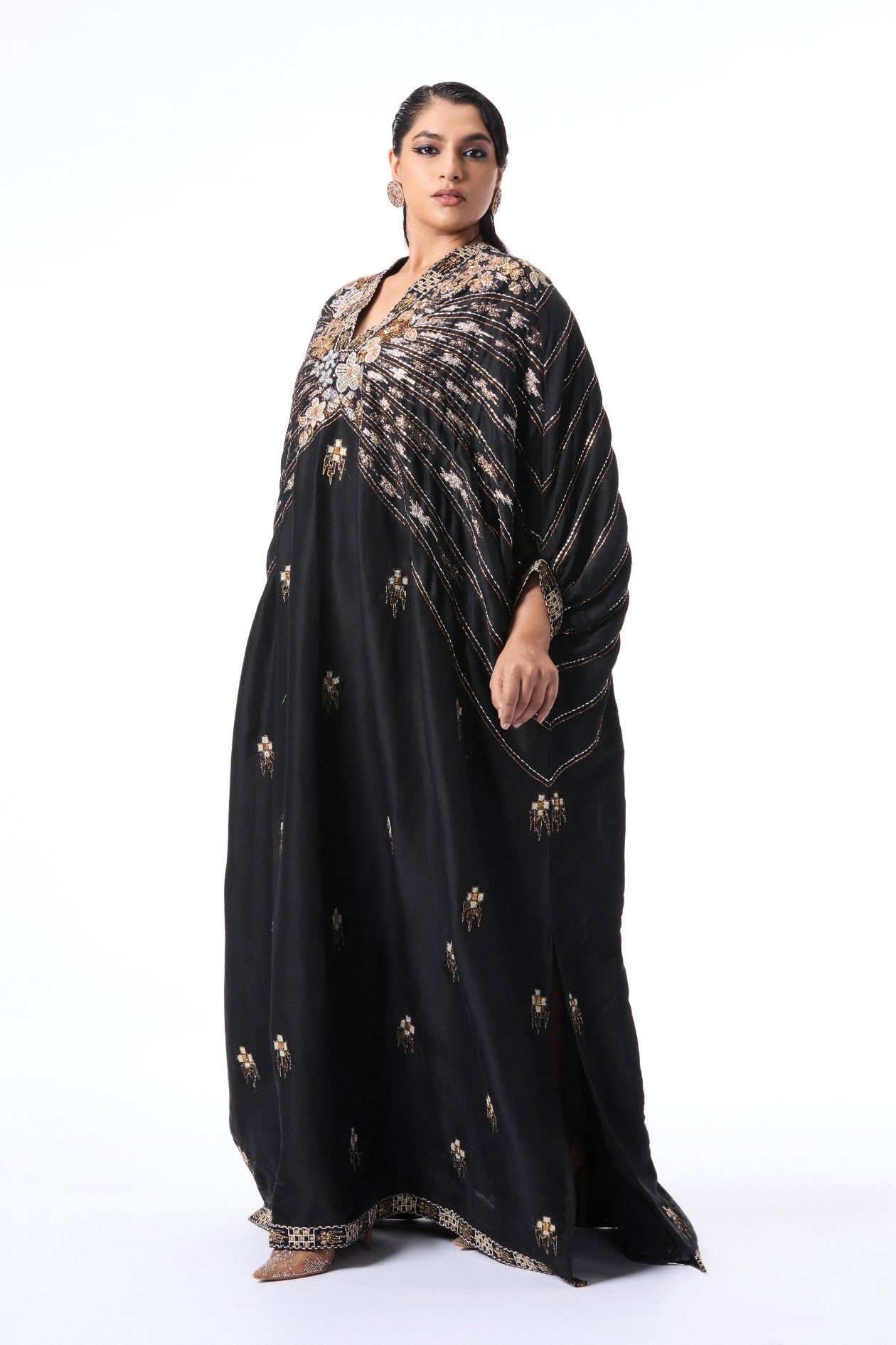 Woman wearing a black kaftan with gold embroidery 