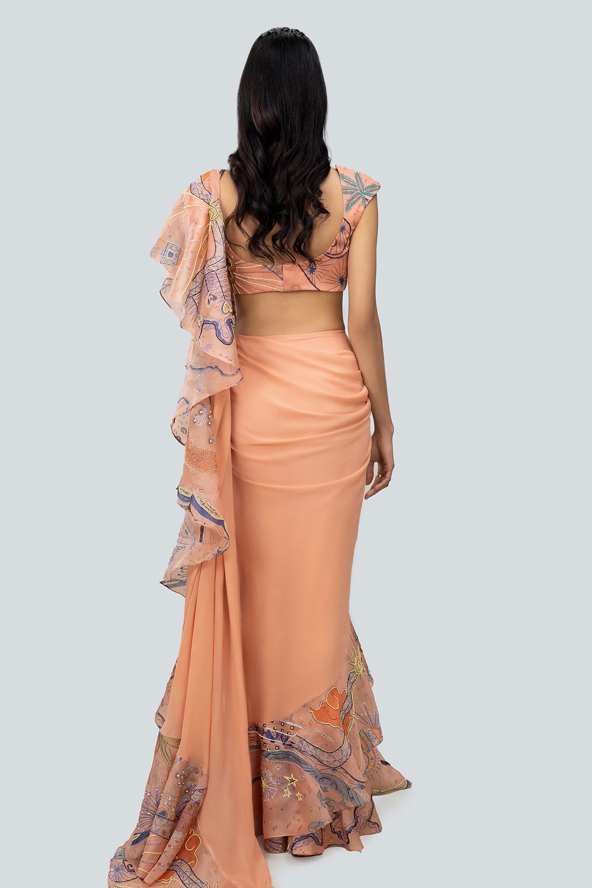 Rear silhouette showing ruffle flow and blouse fit.