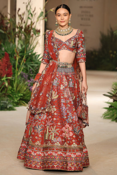 Front view of the Wild At Heart rust raw silk lehenga highlighting applique detailing and the structured blouse