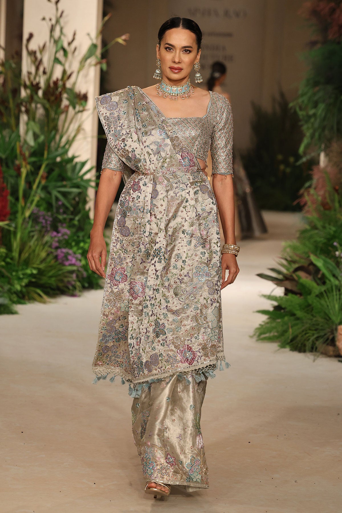 Flowing pallu presenting tissue sheen, brocade depth, and applique embellishment