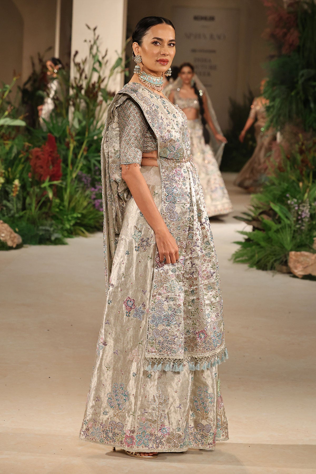 Side profile of the silver banarasi tissue brocade saree highlighting couture drape and embellished accents