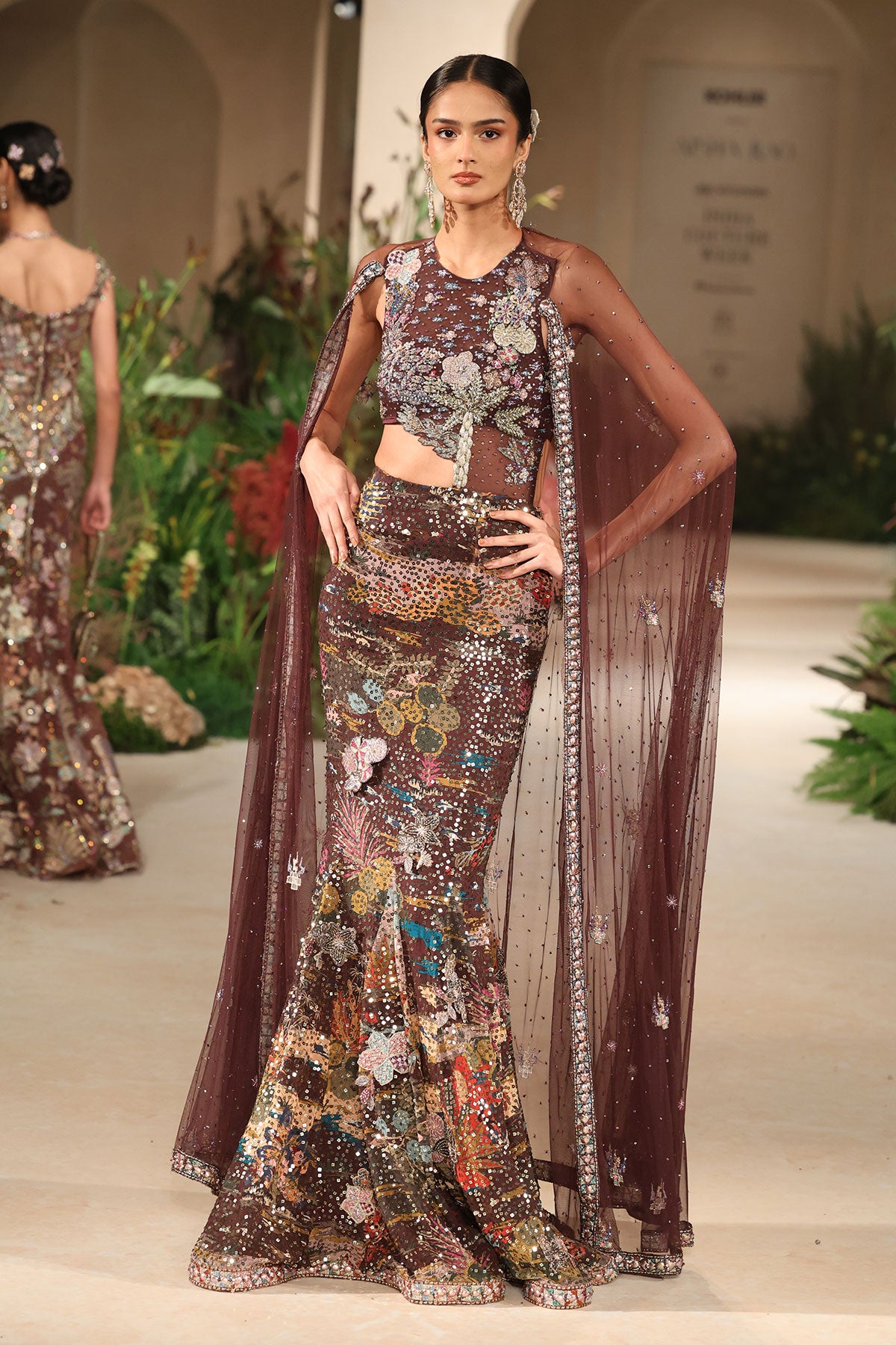 Styled look of the Wild At Heart teakberry applique embellished tulle bodice with printed sequin georgette cape gown