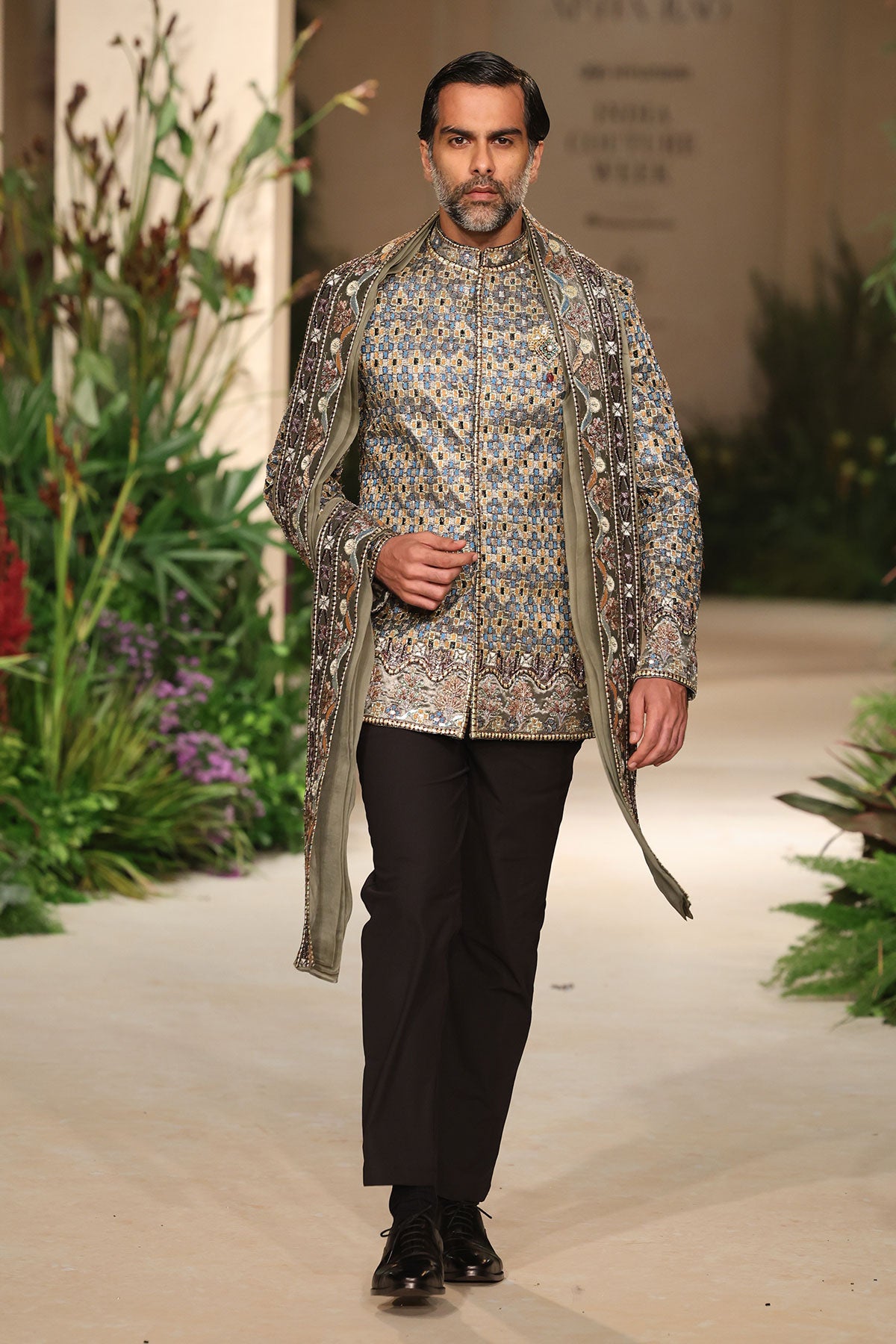 Elegant profile view of the gunmetal applique embellished bandhgala with stole.