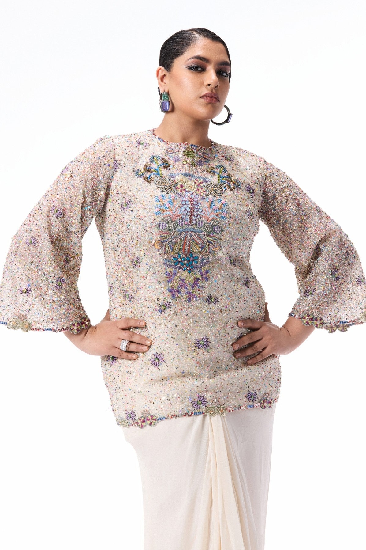 Closeup of the ivory sequin tulle short kurta with applique embellishment.