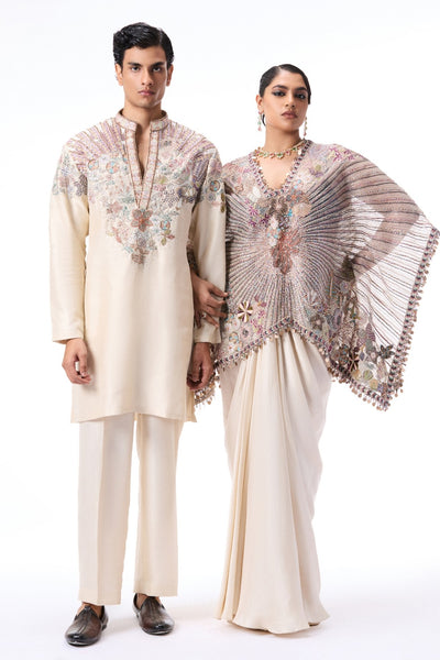 Man and woman in traditional embroidered outfits on a white background