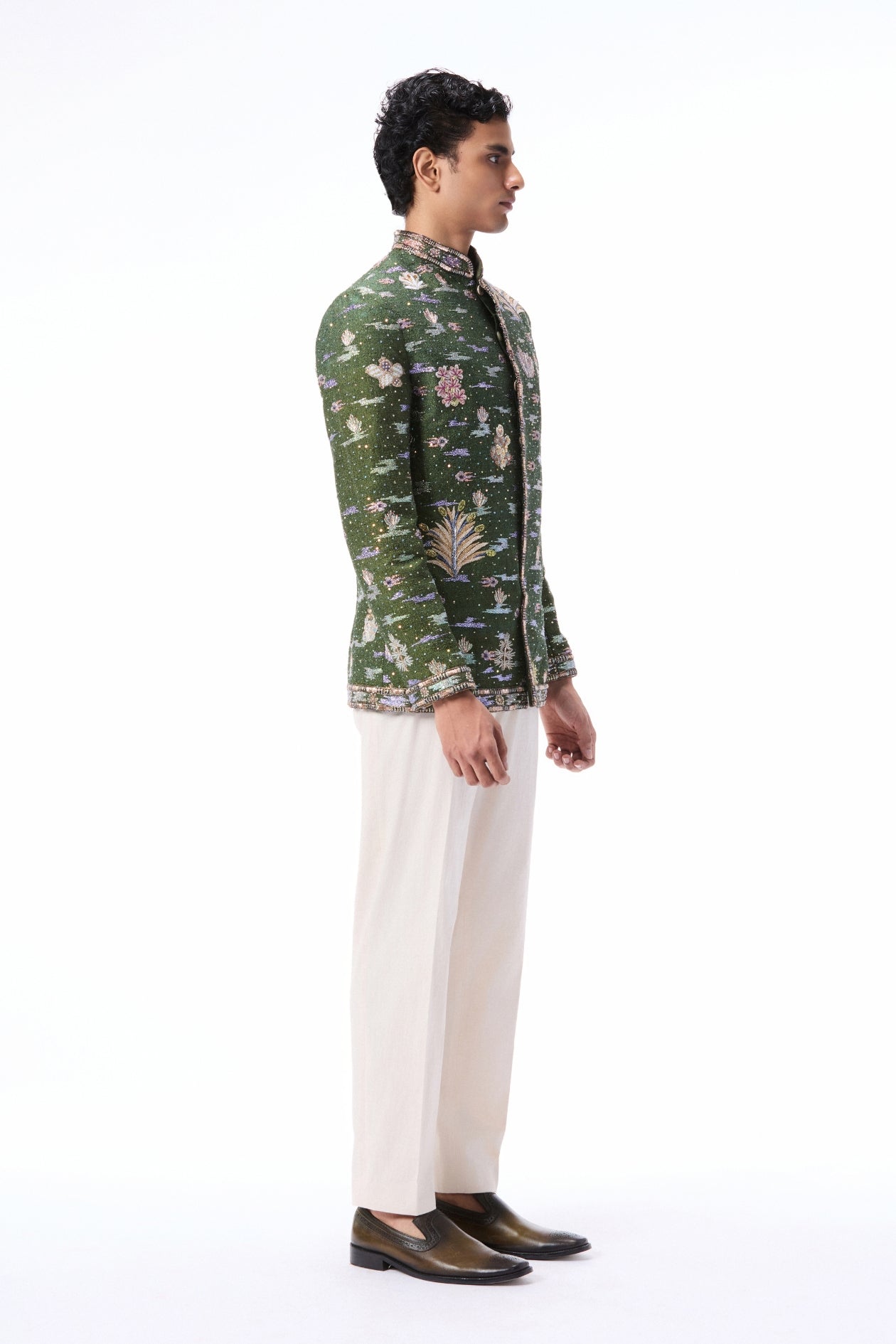 Side angle view of the lush green raw silk bandhgala highlighting applique detailing.