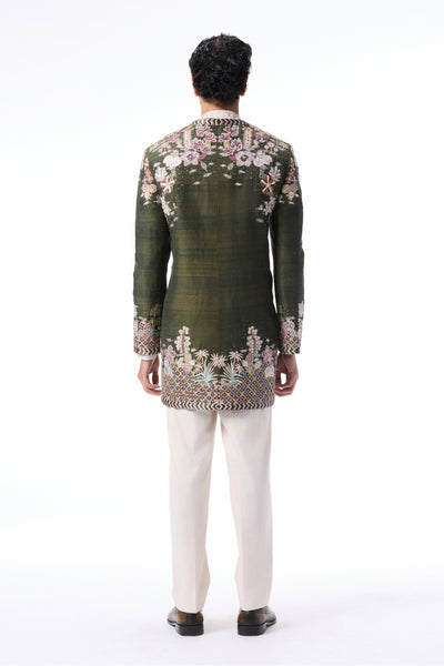 Back profile of the lush green applique embellished raw silk open jacket.