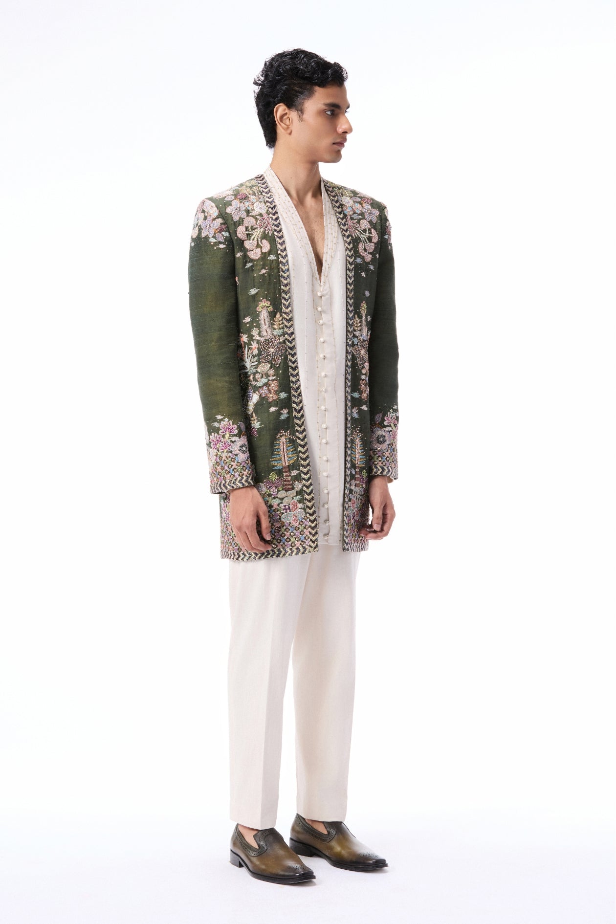 Side angle view of the lush green raw silk open jacket highlighting applique detailing.