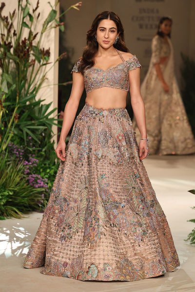 Wild At Heart rose gold Banarasi tissue brocade lehenga shown in a front view with off-shoulder halter-strap tassel blouse and tulle dupatta.