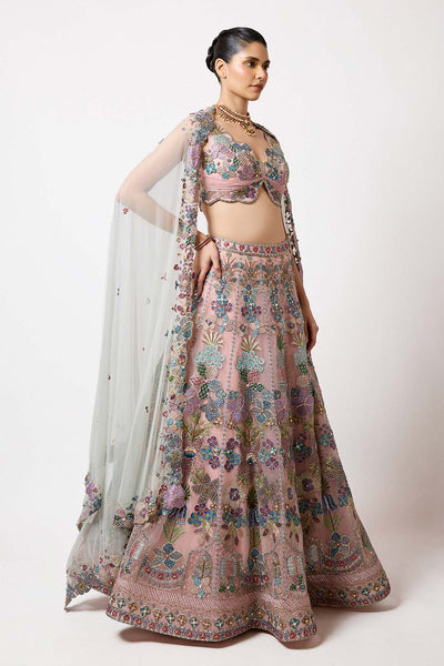 Woman in baby pink applique net lehenga right profile
