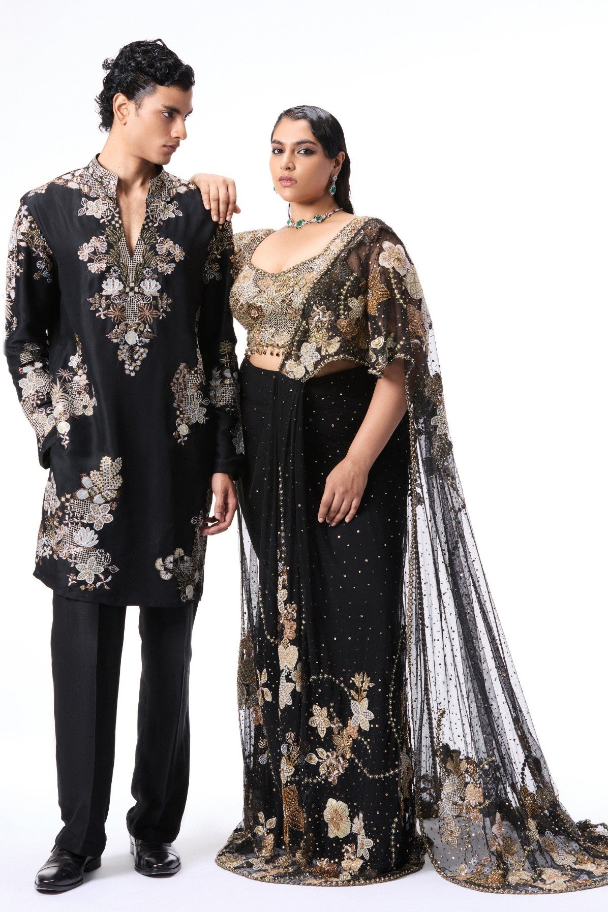 Man and woman in black and gold traditional outfits 