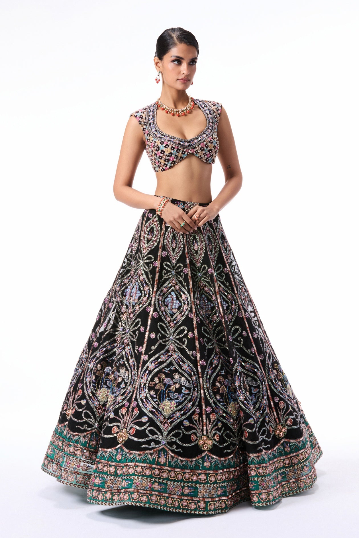 Closeup capturing the applique embellishment on the black-teal layered tulle lehenga.