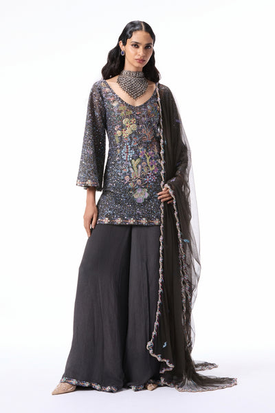 “Gunmetal applique embellished tulle sequin short kurta styled with chiffon sharara pants and a tulle dupatta from the Wild At Heart collection.”