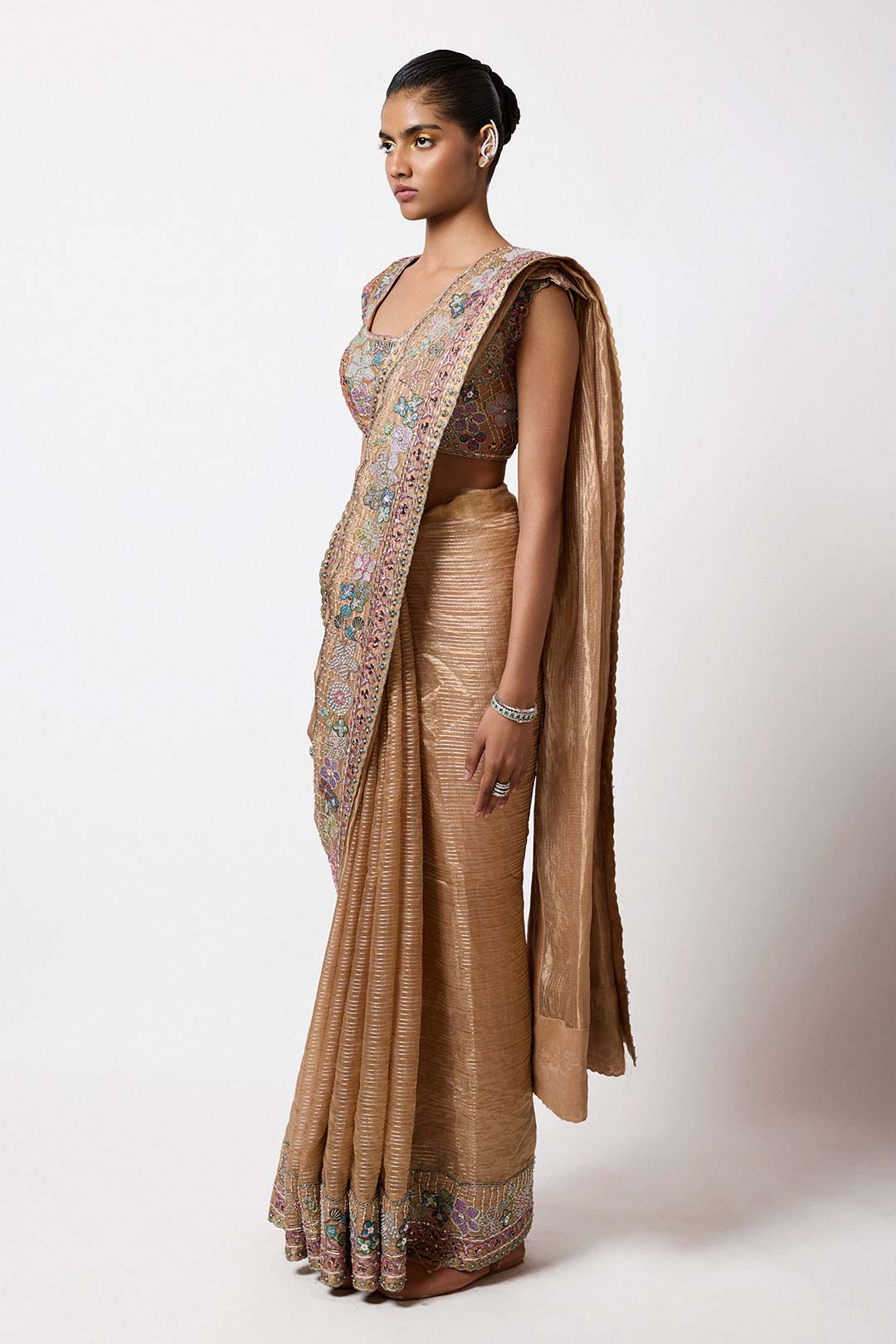 Woman in satin brass tissue ensemble left profile