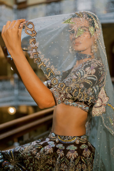 Left side close-up of brown raw silk Aisha Rao lehenga with tulle dupatta