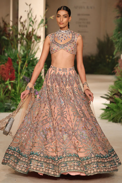 Motion shot capturing the fluid flare of the cantaloupe-teal tulle lehenga.
