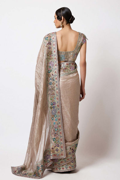 Woman in Aisha Rao embellished champagne look side profile