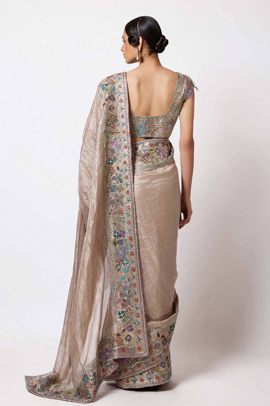 Woman in Aisha Rao embellished champagne look side profile