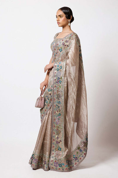 Woman in champagne Banarasi applique attire right profile