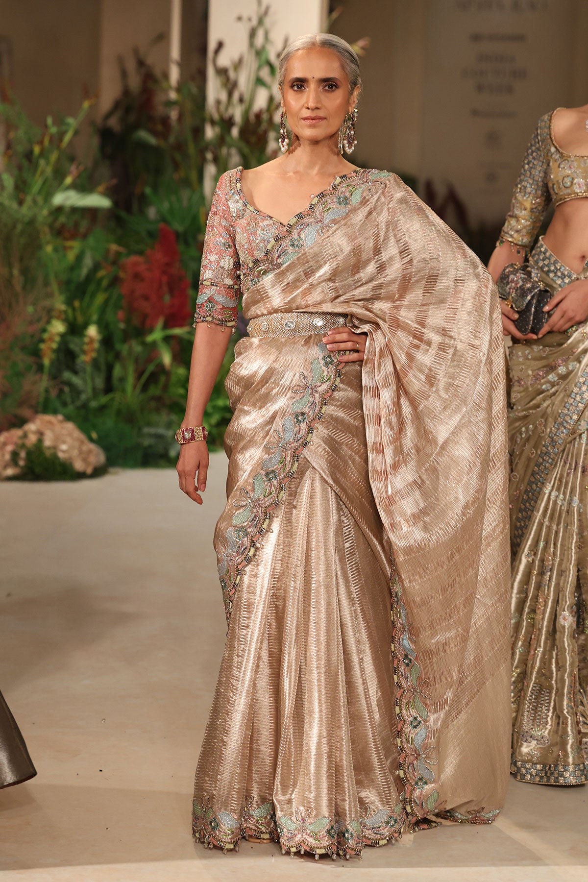“Champagne pink tissue brocade Banarasi saree with ornate border and soft shimmering texture.”
