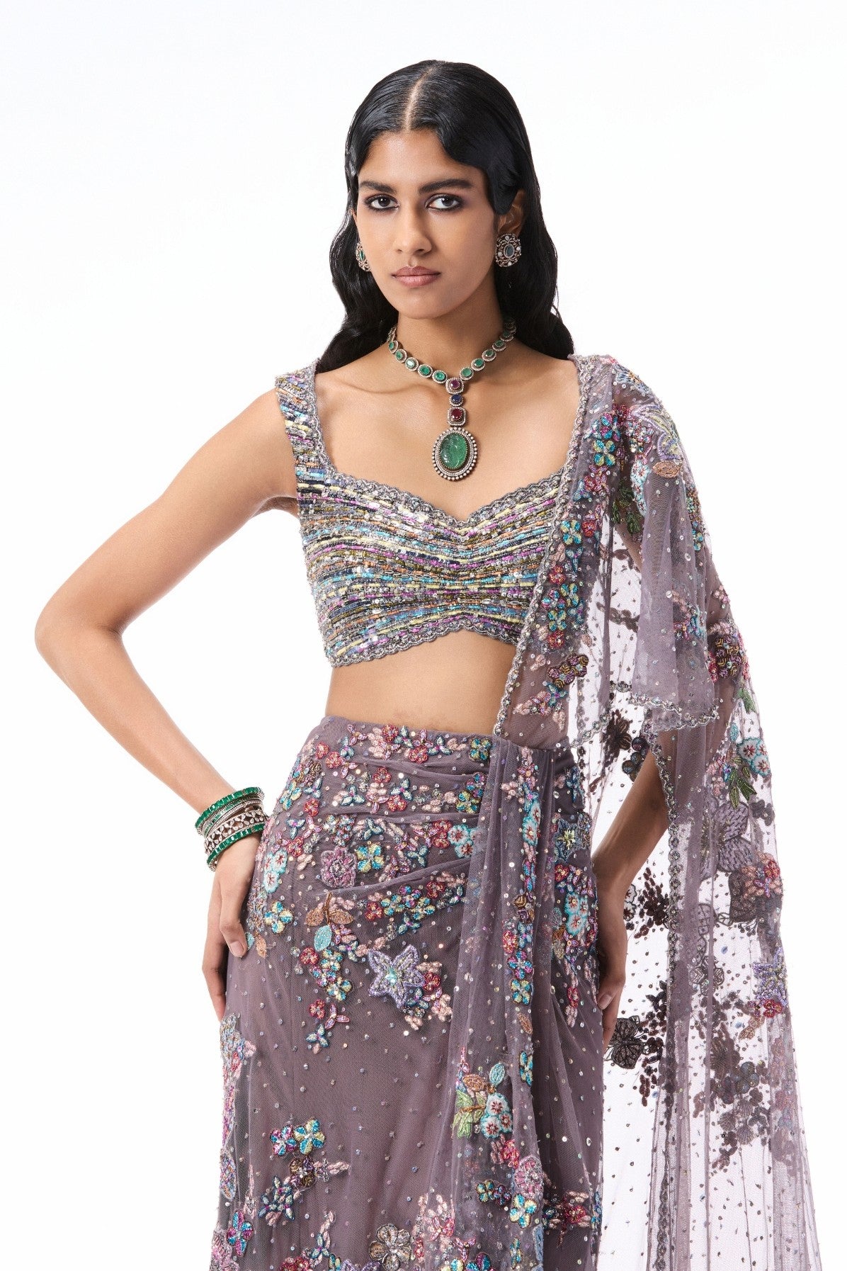 “Gunmetal tulle draped saree styled with a sheer tulle blouse and intricate applique embellishments.”