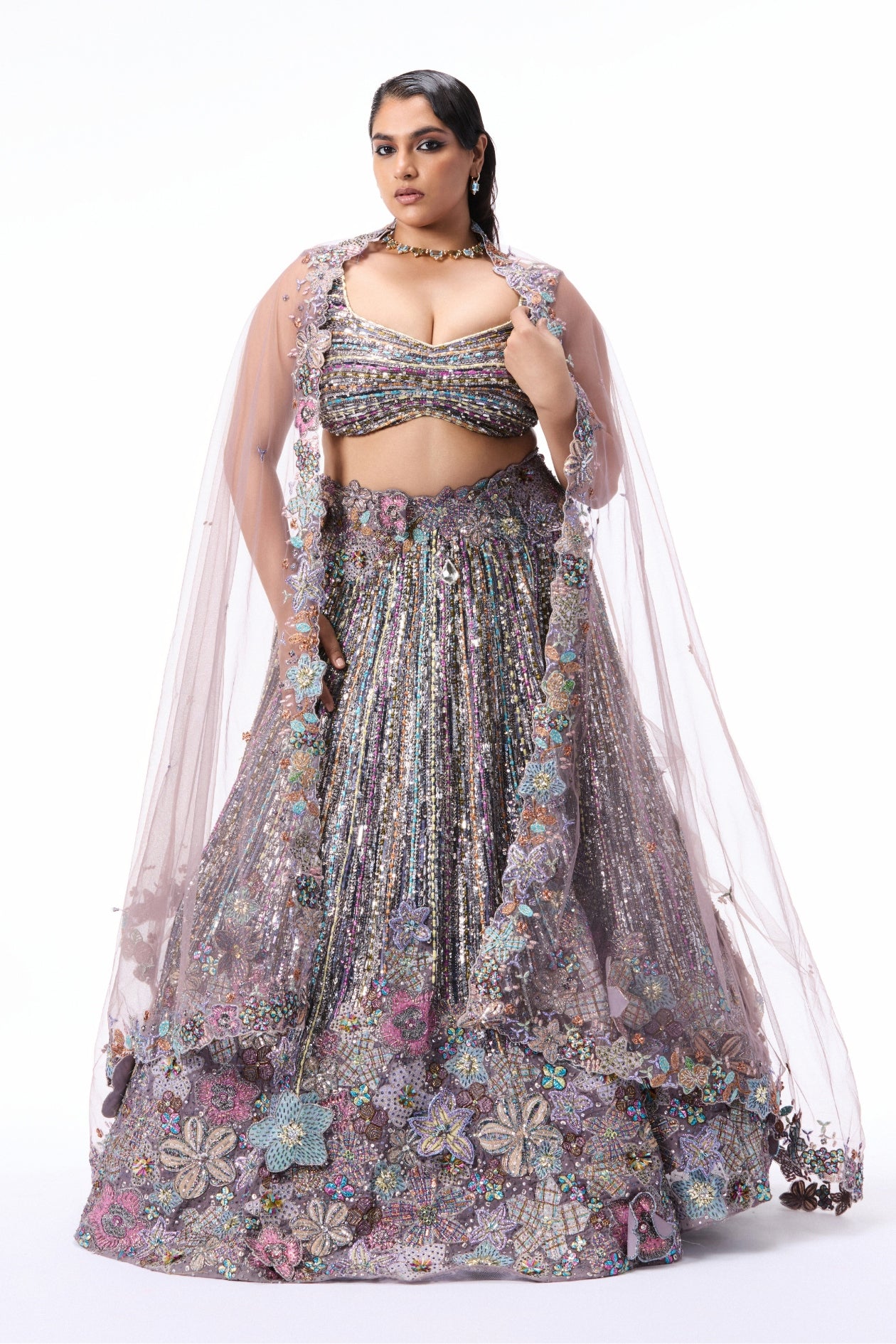 Woman wearing a floral lehenga with a sheer dupatta 