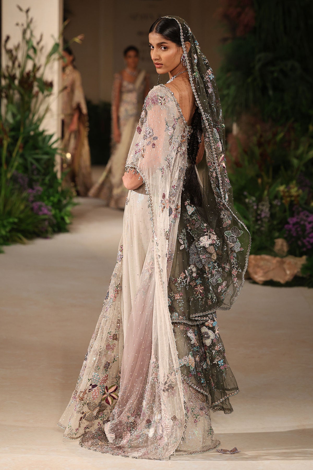 “Ivory tulle saree designed with layered tulle draping and a modern sculpted fall.”