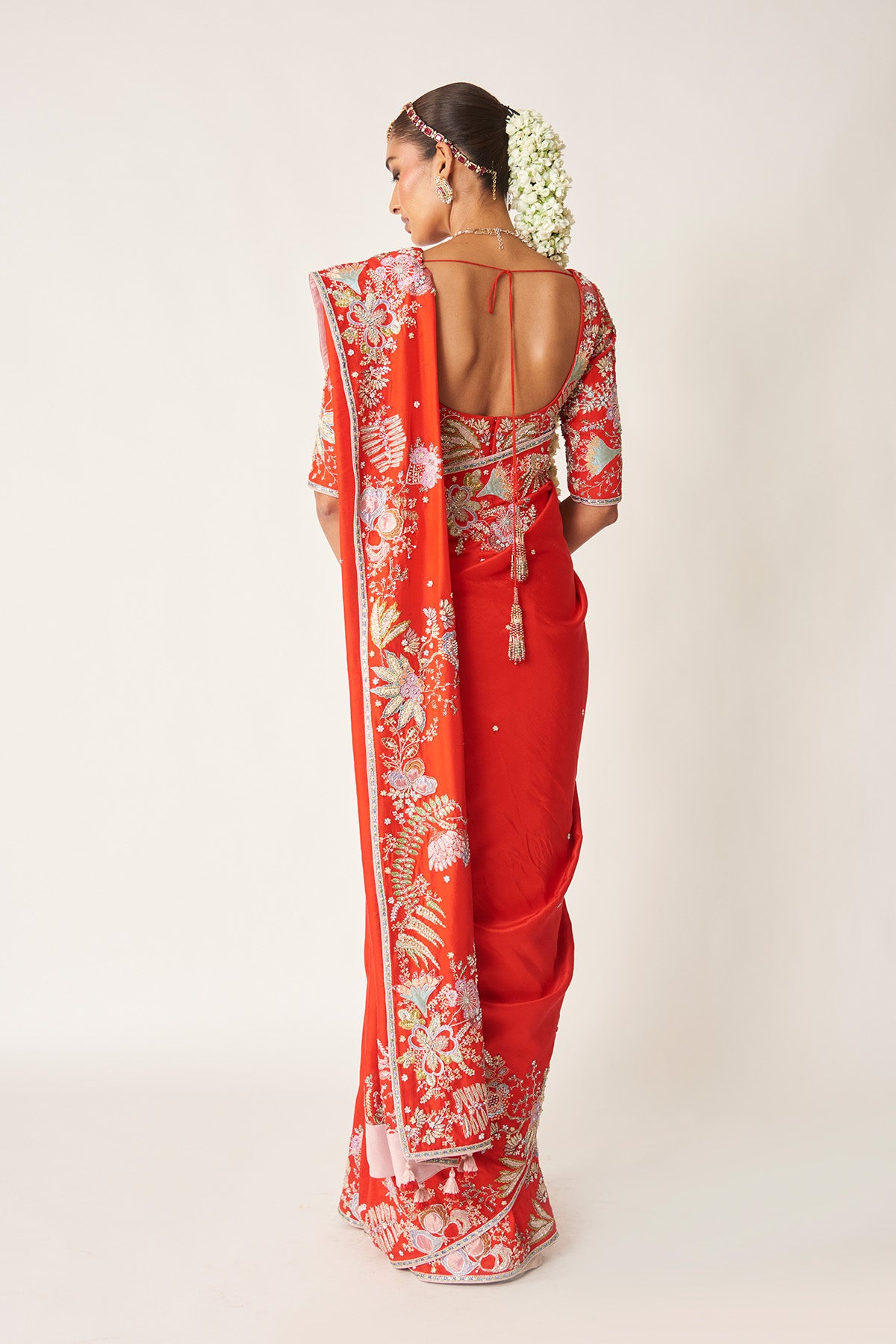 Back look of red embellished blouse and saree