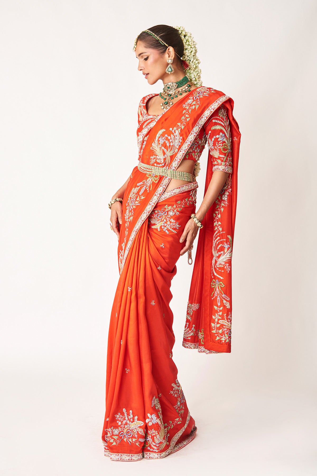 Side angle of red embellished saree with blouse