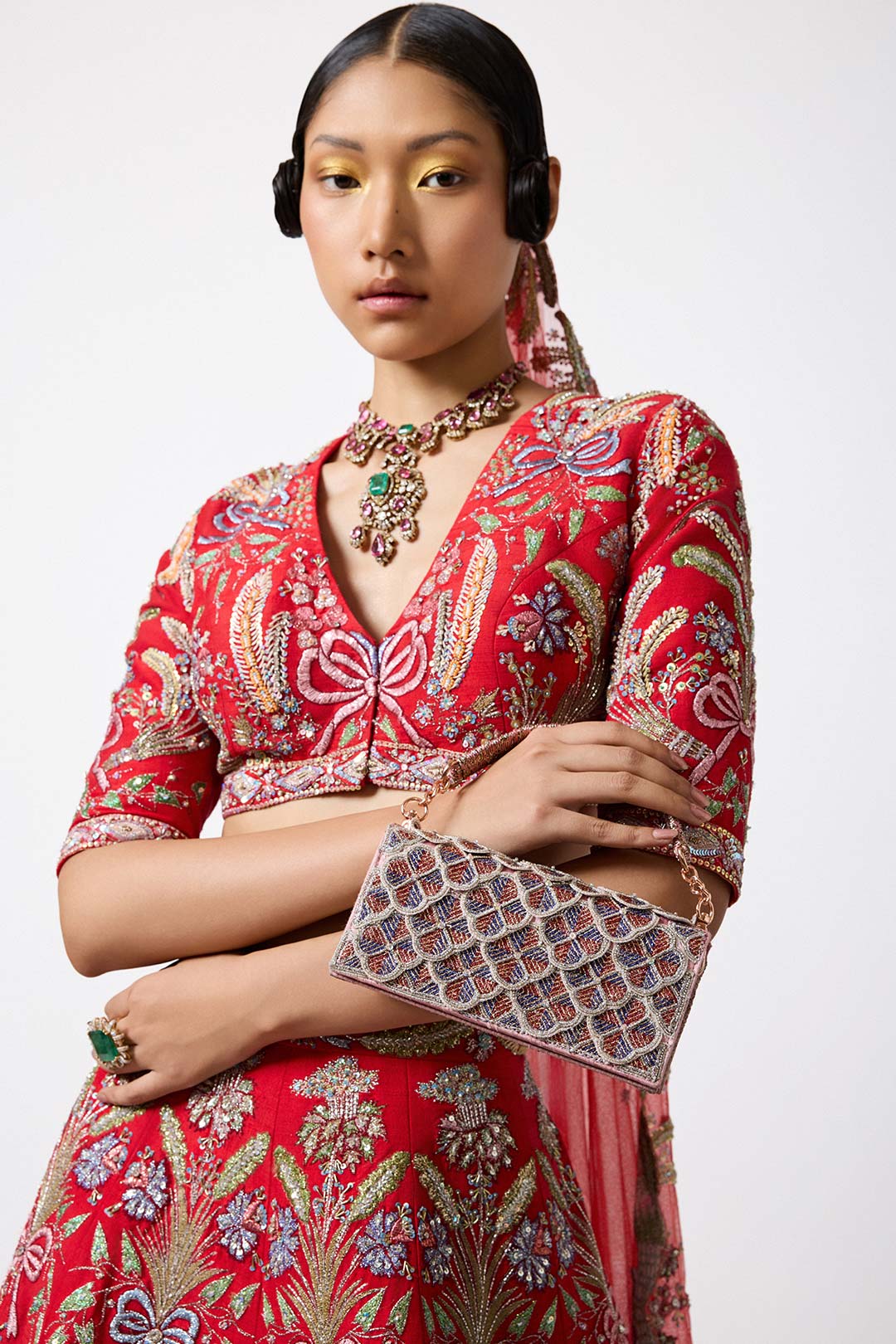 Close-up of bow and blouse from left Aisha Rao red lehenga