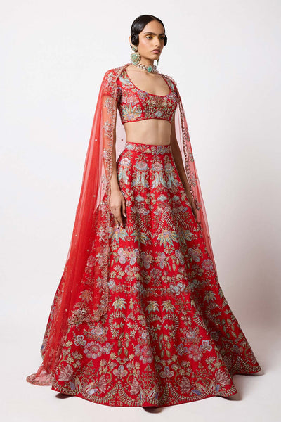 Woman in red applique lehenga and blouse left profile