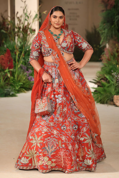 Full look of the Wild At Heart rust raw silk lehenga with embellished blouse, tulle dupatta, and embroidered veil.