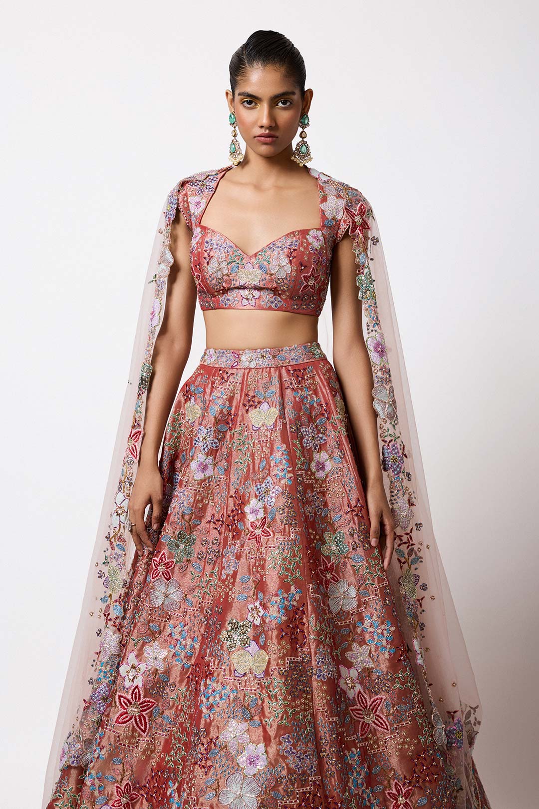 Woman in rust red Aisha Rao lehenga right profile view