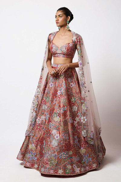 Woman in rust applique embellished lehenga left profile