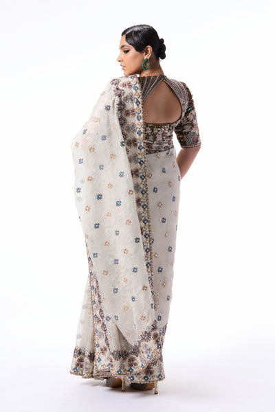“Designer silver Banarasi tissue brocade saree showcasing applique border accents and a refined tissue blouse.”