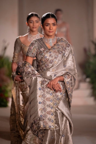 “Silver Banarasi tissue brocade saree with applique detailing and V-neck blouse from Wild At Heart.”