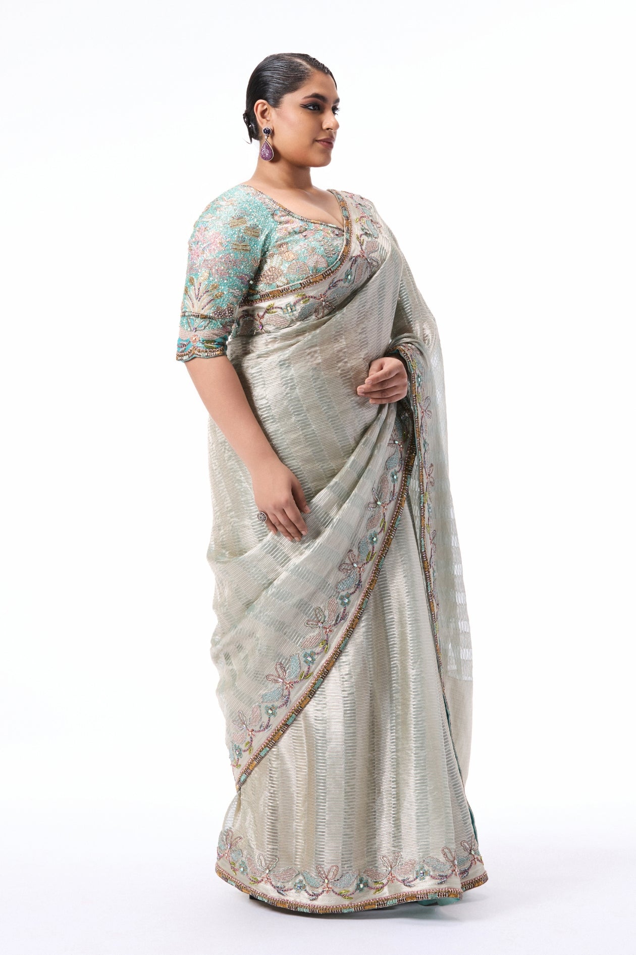 “Blue and silver Banarasi tissue brocade saree from Wild At Heart featuring a detailed applique border.”