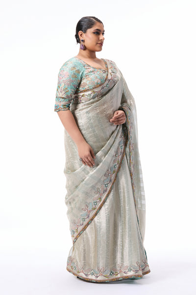 “Blue and silver Banarasi tissue brocade saree from Wild At Heart featuring a detailed applique border.”