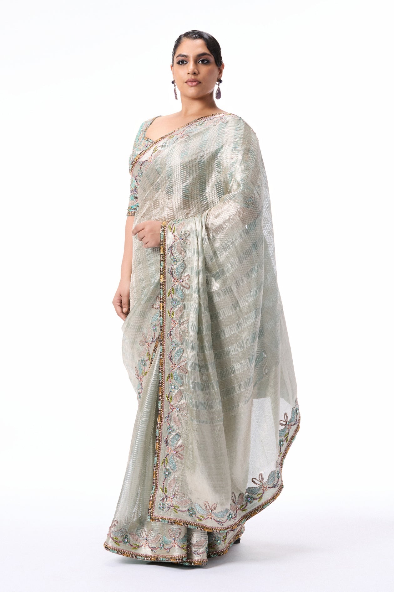 “Silver tissue brocade saree with blue undertones, enriched with silver applique border and blue blouse.”
