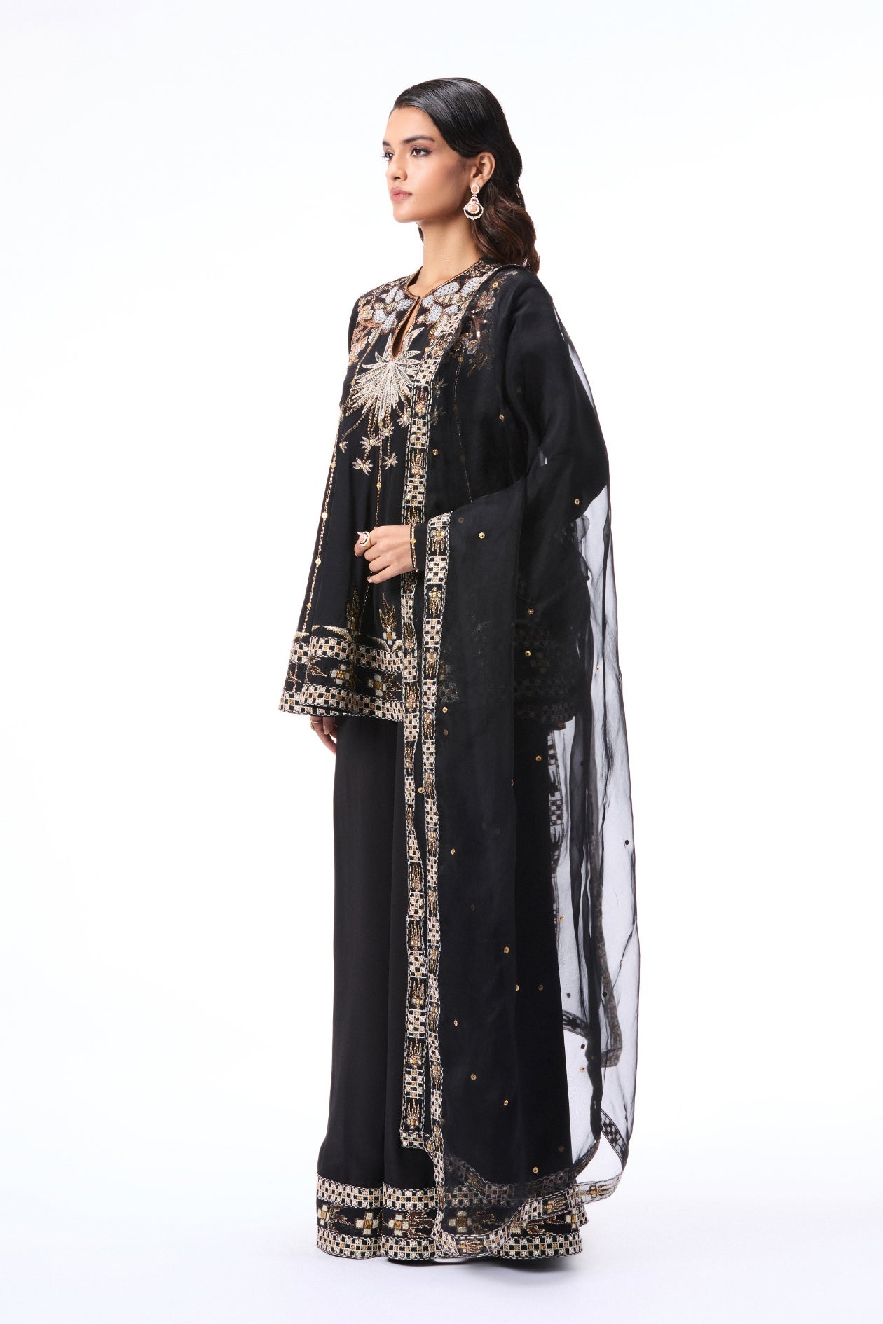 Woman wearing a black embroidered outfit 