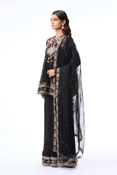 Woman wearing a black embroidered outfit 