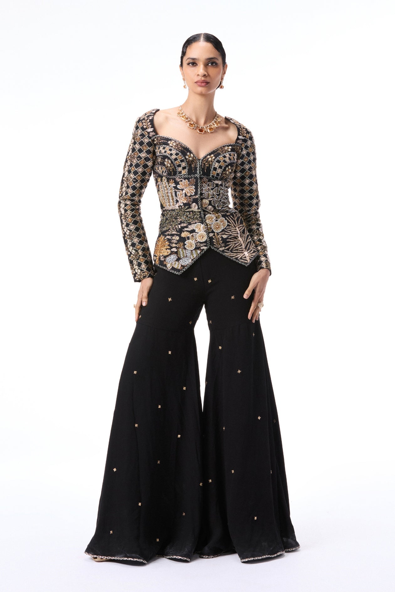 Front view of black applique embellished raw silk top with double georgette gharara pants