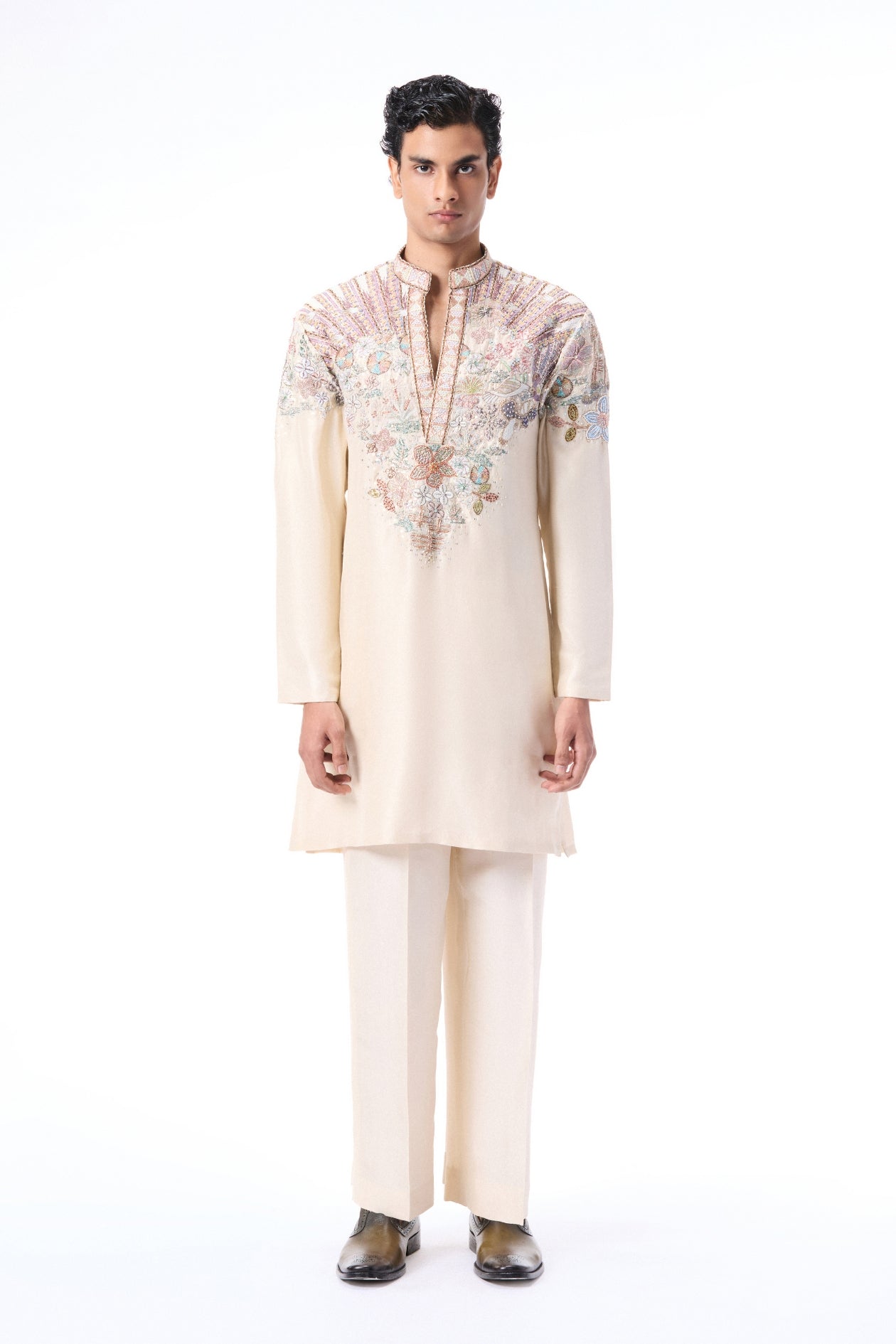 Man wearing a cream kurta with floral embroidery 