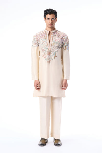 Man wearing a cream kurta with floral embroidery 