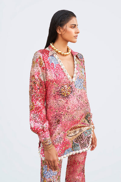 Close-up of sequin appliqué and shell trim on dress tunic neckline.