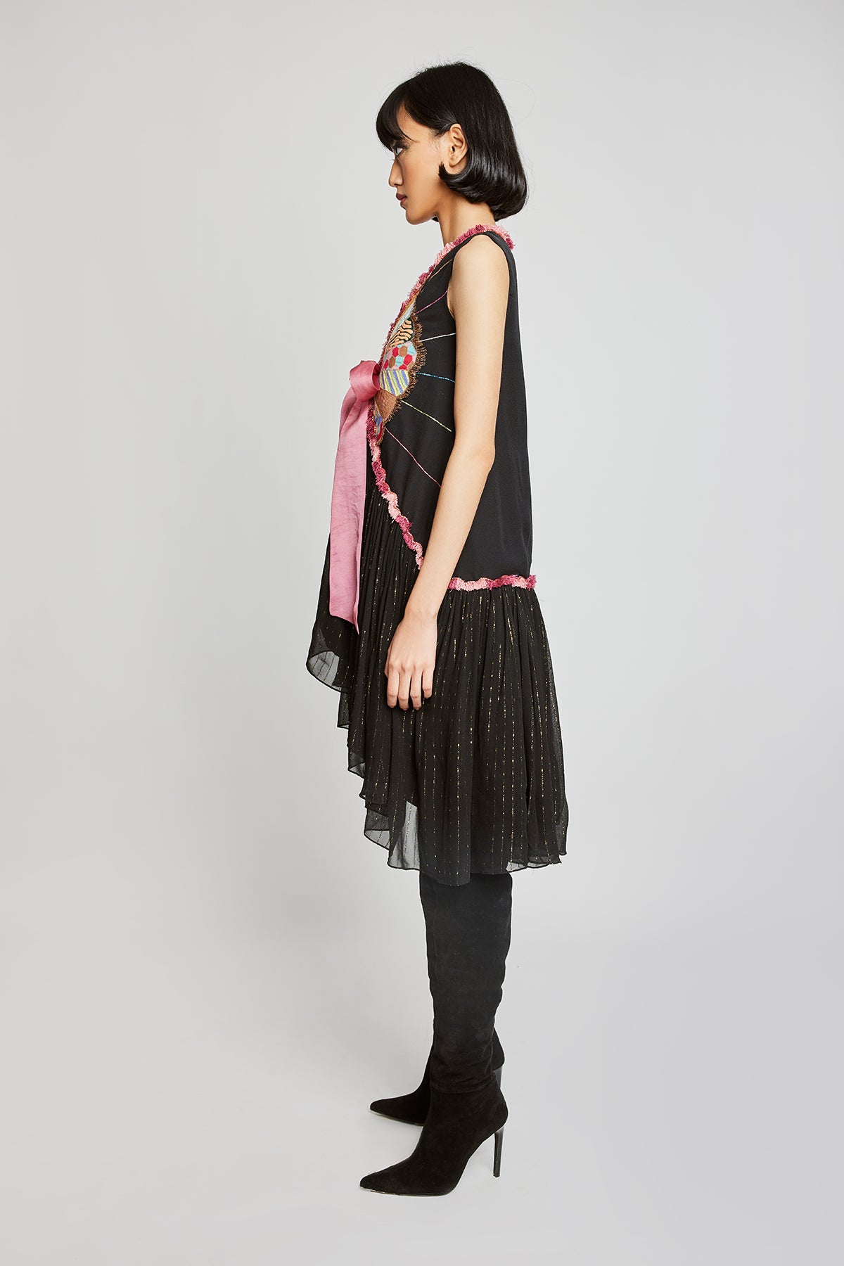 Left side view of Trencadís black dobby appliquéd dress with bow-tie detailing