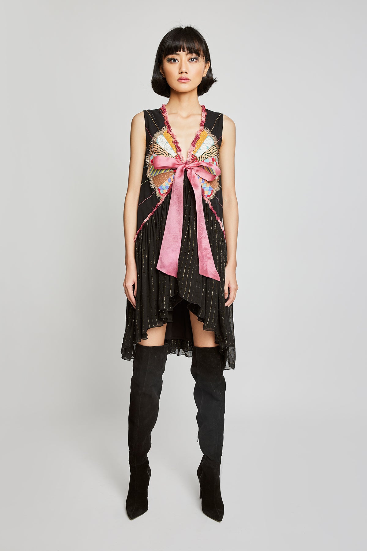 Front view of Trencadís black dobby appliquéd dress with bow-tie detailing

