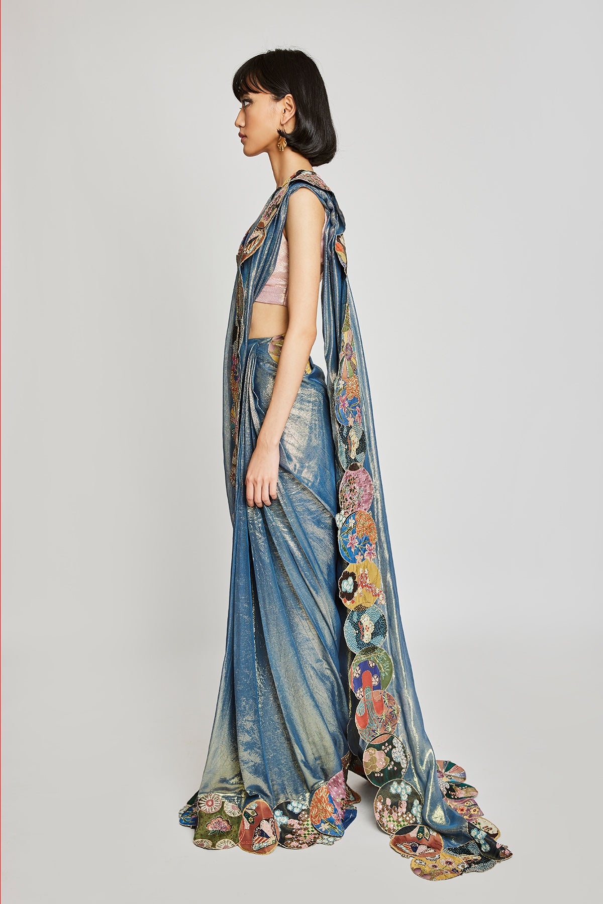 Close-up of embellished circle border and blouse embroidery on saree front.